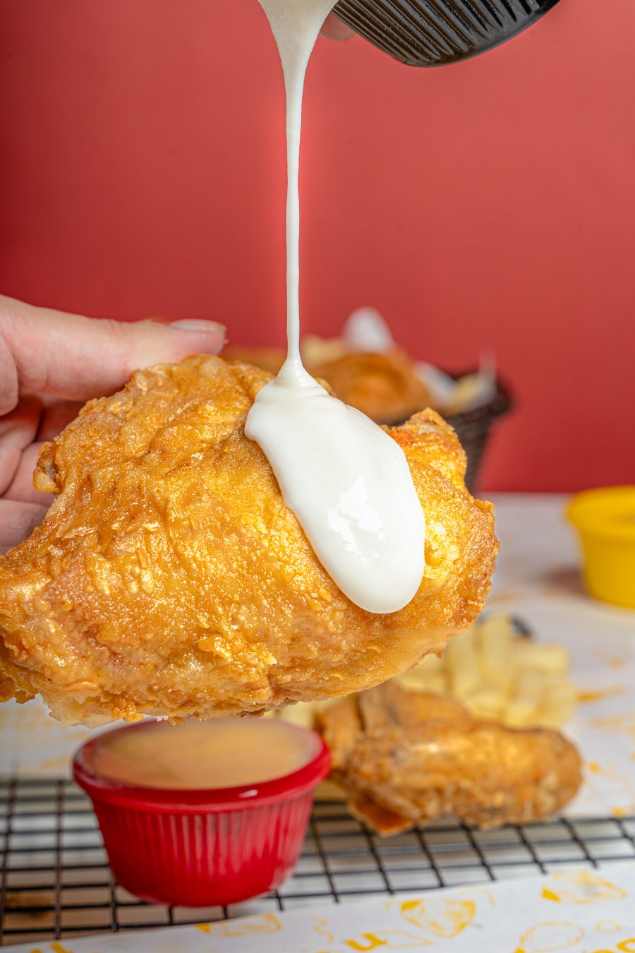 Garlic sauce poured over a piece of broast