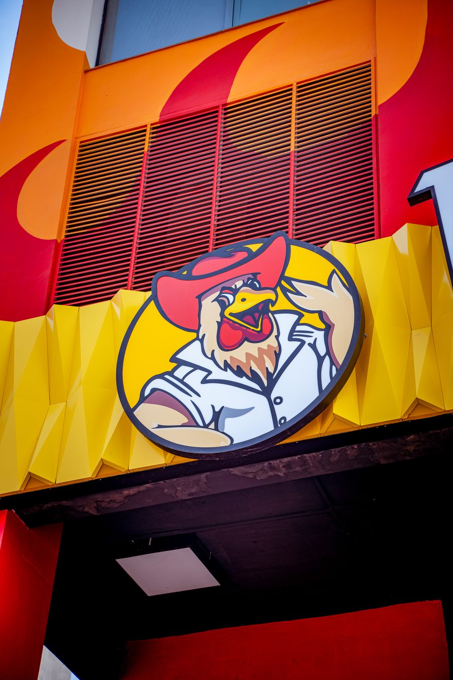 The hen n' bun rooster logo on a branch sign