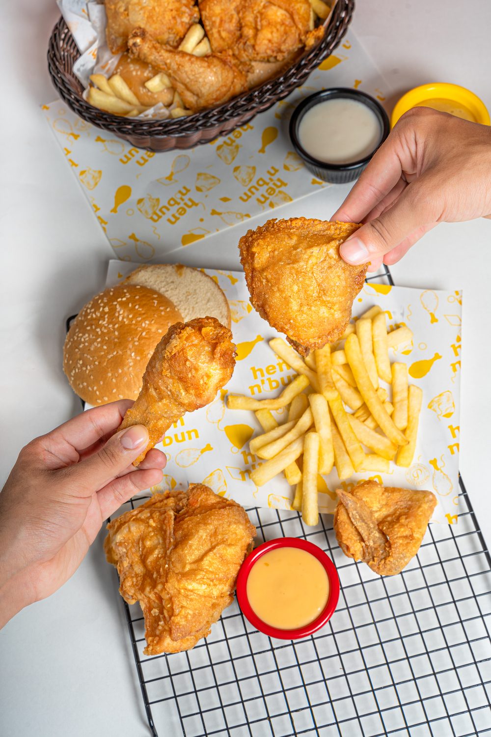 Friends sharing hen n' bun broast, fries and dips