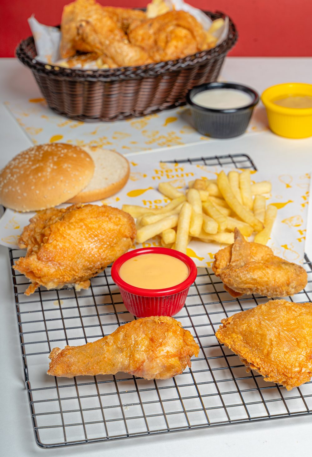 A basket of hen n' bun broast with fries and dips
